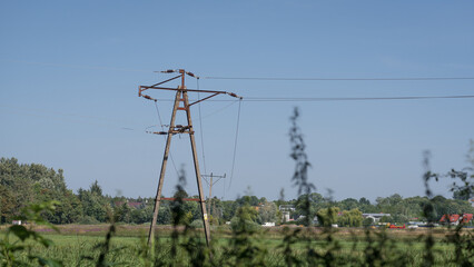 Obraz premium ENERGETICS - Medium voltage line over green pastures and meadows