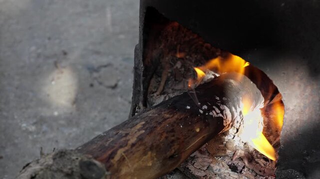 Bright flames burning under a cauldron outdoors. Rustic campfire cooking with glowing firewood and traditional atmosphere