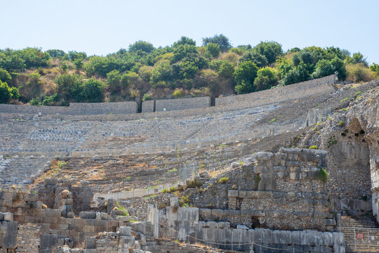 View of the Great Theatre at Ephesus Ancient City with its tiered stone seating, historic ruins, and surrounding hillside in Selcuk, Izmir, Turkiye.