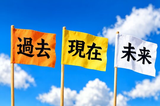 青空を背景に過去と現在と未来の文字が書かれた三色の旗が立てられているコンセプト写真