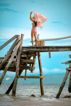 Woman tourist in happiness and relax moment on wooden pier, enjoy the summer trip in tropical island