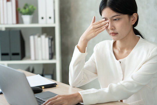 Eye problems, Asian women open eyes due to eye irritation, eye rubbing, dry, eye pain after work, migraine, headache, blurred vision, photophobia, working in the dark, blue light from computer screens