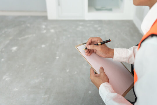 inspector or engineer is inspecting construction and quality assurance new house using a checklist. Engineers or architects or contactor work to build the house before handing it over to the homeowner