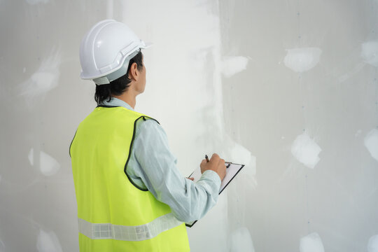 inspector or engineer is inspecting construction and quality assurance new house using a checklist. Engineers or architects or contactor work to build the house before handing it over to the homeowner