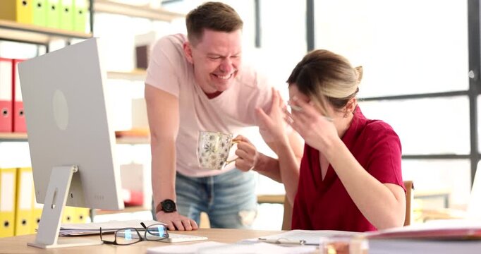 Two colleagues enjoy a lighthearted exchange in a lively office. Their laughter fills the air as they engage with enthusiasm and friendly camaraderie amidst colorful folders.