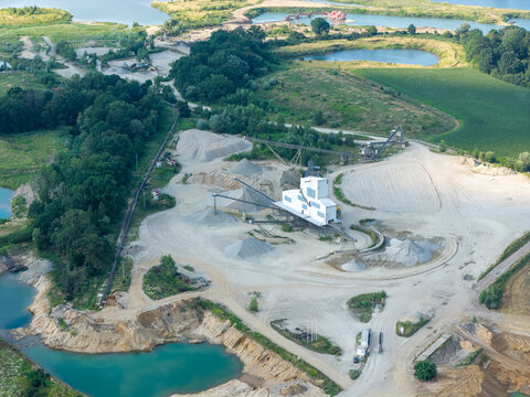 Aerial view of a sand and gravel quarry with industrial machinery and water bodies