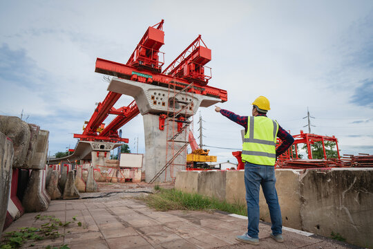 Asian workers are employed at a construction site for a new concrete bridge, a crucial infrastructure project for heavy urban transportation and bypass roads.