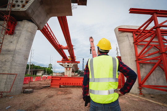 Asian workers are employed at a construction site for a new concrete bridge, a crucial infrastructure project for heavy urban transportation and bypass roads.