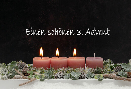 Einen sch&ouml;nen 3. Advent. Grusskarte mit drei brennenden altrosa Kerzen auf modernem Adventsgesteck vor dunklem Hintergrund.