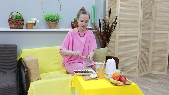 woman using wooden tongs to place dried butterfly pea fruits for herbal tea