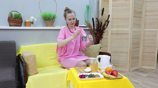 woman stirring butterfly peas in a mug of boiling water with a spoon