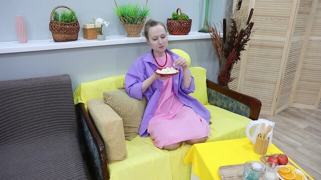 woman happily eats popcorn from a bowl