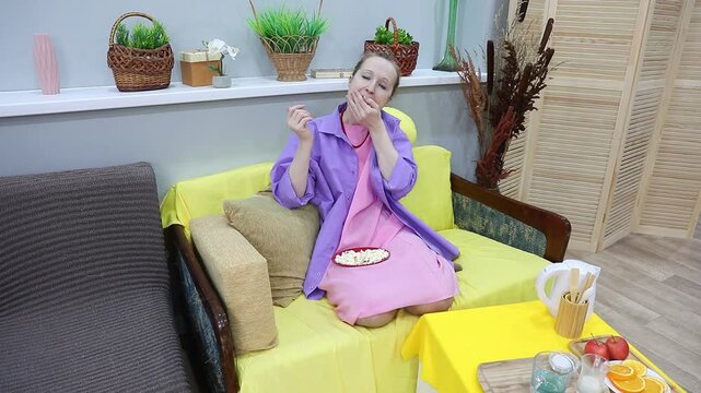 woman happily eats popcorn by the handful