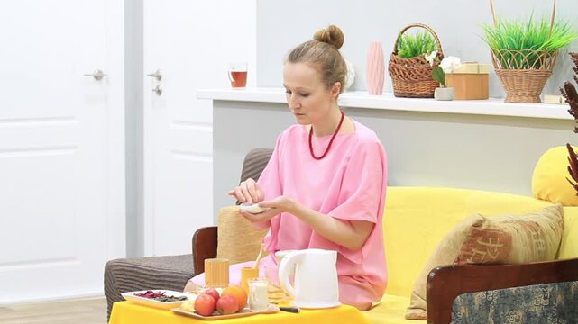 woman smelling and tasting tea leaves from a special bowl, side view