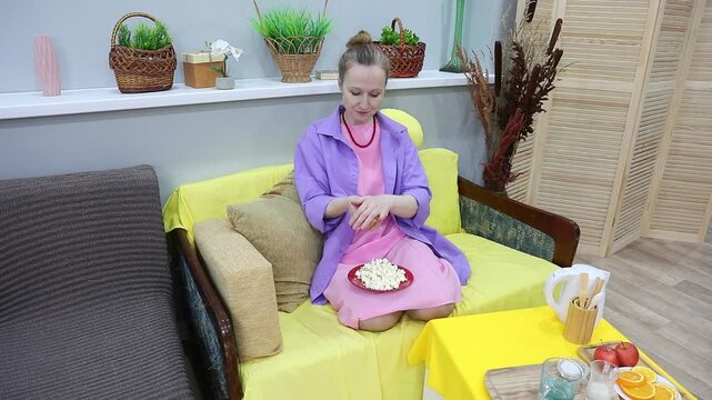woman eating popcorn from a handful