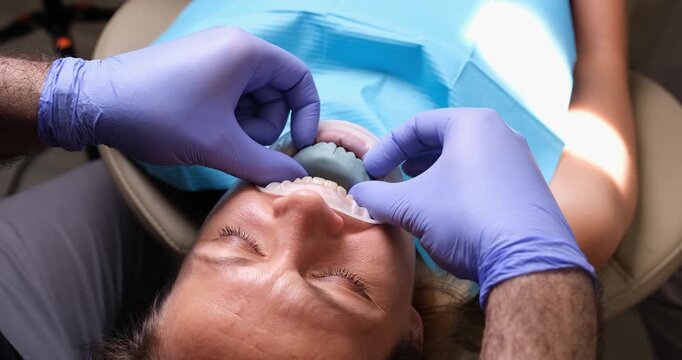 A patient receives attentive dental care in a modern clinic, as professionals fit a dental appliance. Care and precision are evident throughout the process, ensuring comfort.