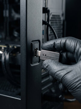 Gloved Hand Stealthily Plugging USB Memory Flash Drive into Computer USB Port