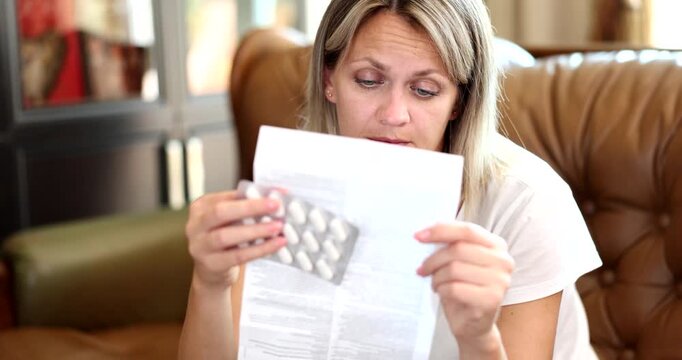 In a cozy living room, a woman sits thoughtfully, studying medical information. Her expressions reflect concern and contemplation while she processes critical health details.