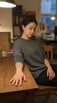 Thoughtful woman in a quiet warm-lit workspace
