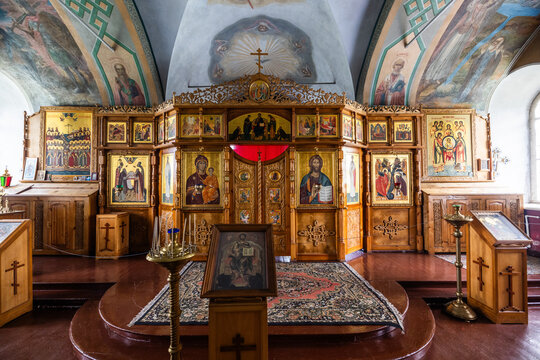 View of the ornate wooden iconostasis with golden icons and religious paintings inside a church at the Solovetsky Islands, Solovetsky, Arkhangelsk Oblast, Russia.