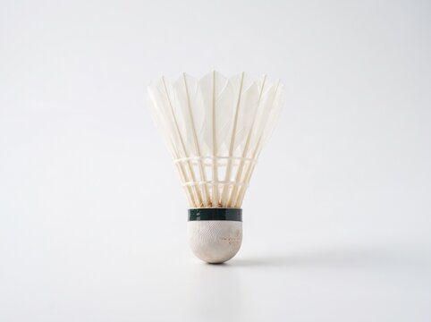 Classic white badminton birdie isolated on a plain background, perfect for fitness concepts and equipment advertising.