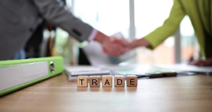 Business professionals passionately discuss trade opportunities while shaking hands, sealing agreements in a vibrant, sunlit office environment.
