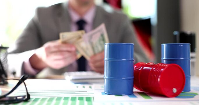 In a lively office setting, a well-dressed person counts stacks of cash beside colorful cups. The atmosphere buzzes with energy, showcasing focus amid creativity.