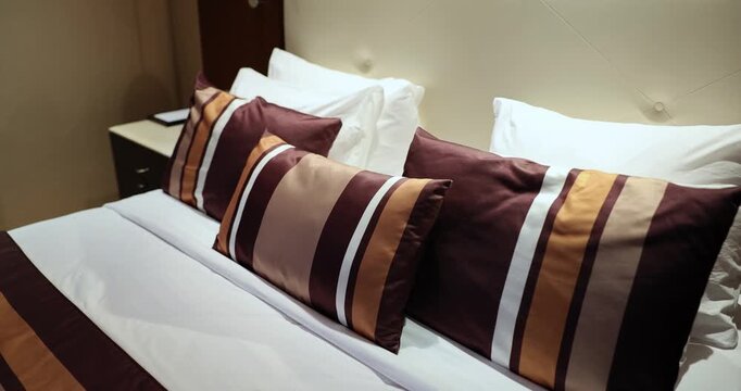 Discover the warmth and charm of a beautifully styled bedroom filled with soft pillows and rich, deep colors. Cozy elegance invites relaxation in this intimate space.