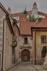Obraz premium Historic narrow cobblestone street leading to a view of the famous Bratislava Castle in the old town, Slovakia