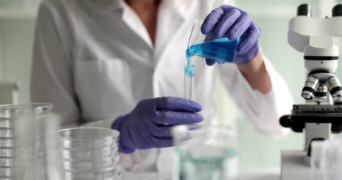 In a modern laboratory, a dedicated researcher skillfully handles liquid samples while using precision tools. Bright light illuminates the vibrant colors of the experiments.