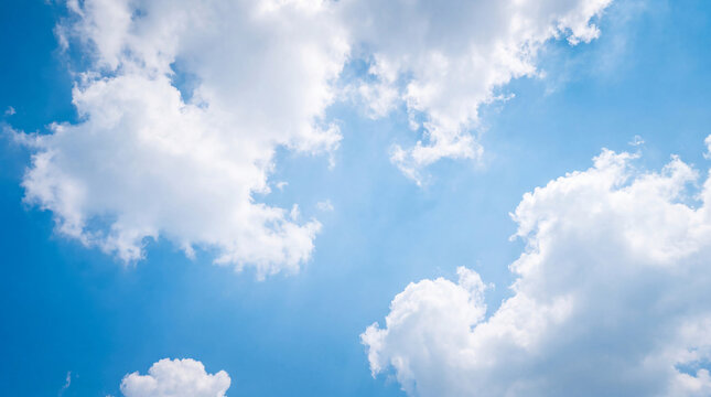 Picturesque white cumulus clouds drift gracefully across a brilliant blue sky.