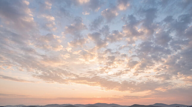 Majestic golden hour sky with textured clouds over a scenic landscape featuring rolling hills and shimmering water.
