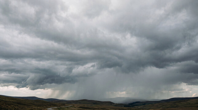 Expansive, hilly landscape under a dark, ominous sky with heavy storm clouds and sheets of rain.