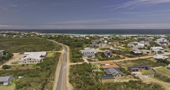 Betty's Bay South Africa Aerial v1 low flyover above coastal homes and fynbos with ocean shoreline and mountain views - Shot with Mavic 3 Pro Cine - Jan 9th 2024