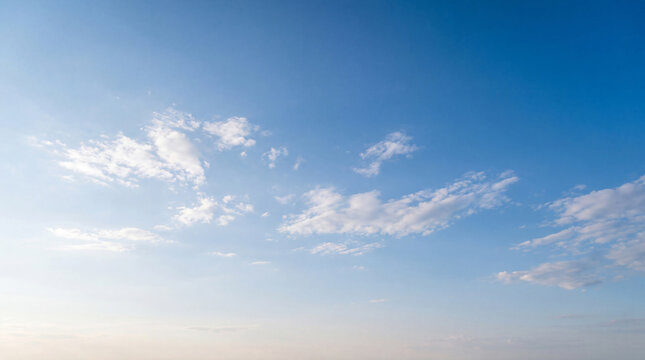 Clear blue sky with small, delicate white clouds scattered across a serene, expansive backdrop.