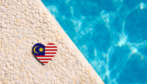 Malaysia flag in the shape of a heart near the pool in the hotel. Holiday concept in hotels