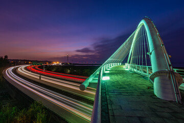 Illuminated arch bridge and freeway light trails at dusk in Taiwan © 柏佑 鄧