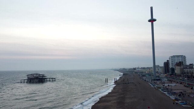 Rising drone shot of tall observation tower i360 and cityscape opposite the burnt down pier and ocean