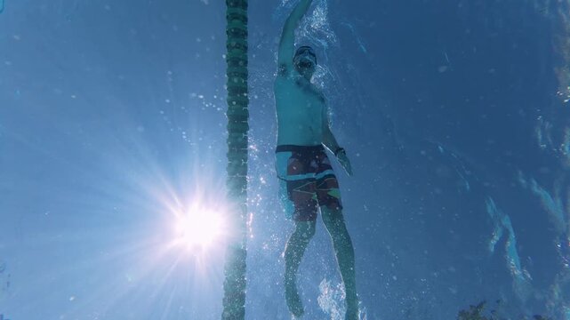 Low Angle View of Man Swimming Front Crawl in Sunny Pool