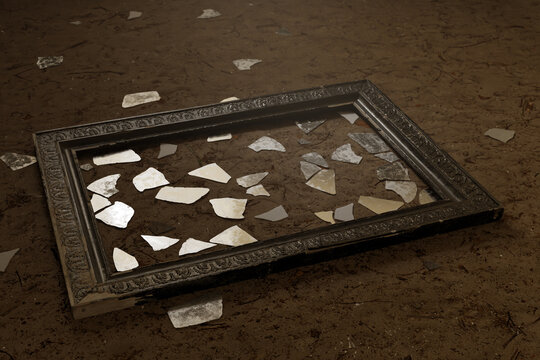 3d rendering of vintage picture frame with scattered glass shards laying on sandy soil