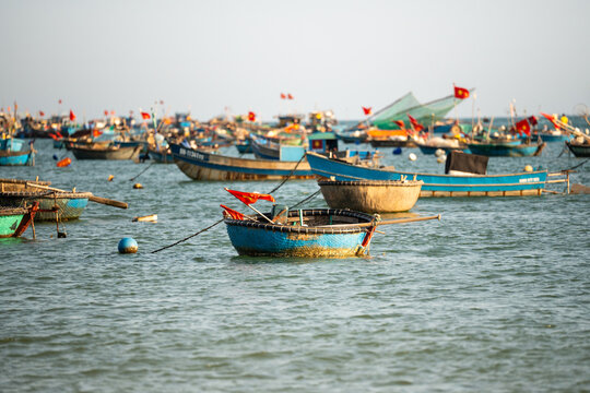 Various Vietnamese boats for seafood fishing and transportation at bay with equipment on board, traditional local fishermen fleet with round basket boats on water 