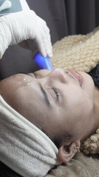 Female patient receiving dual radiofrequency and ultrasound facial treatment at an aesthetic clinic for skin tightening and jawline contouring