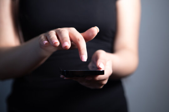 A young woman  holds a smartphone in her hands
