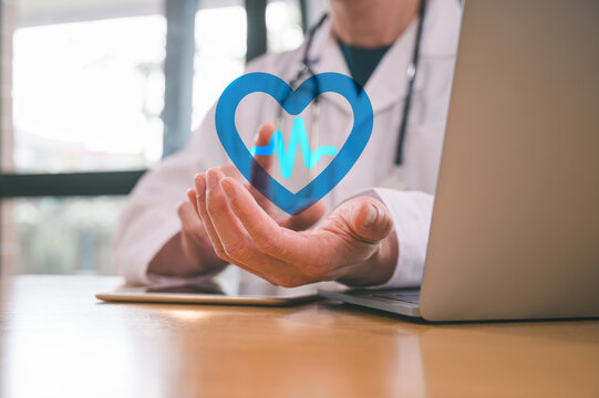 Medical health and wellness concept, Doctor holding a blue heart icon at hospital office. Medical health care and doctor staff service.
