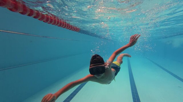 Boy Swimming Underwater with Mask in Swimming Pool