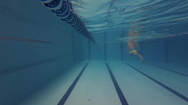 Boy Swimming with Fins Underwater in Pool Lane