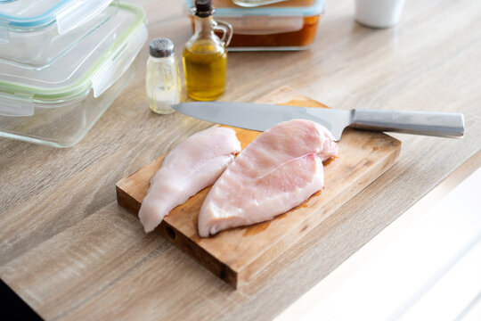 Raw Chicken Breasts with Knife on Wooden Cutting Board