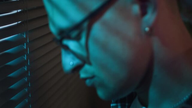 Young adult Caucasian man with glasses playing video games late at night, eating popcorn and drinking energy drink. Footage suits commercials about technology overuse and mental health