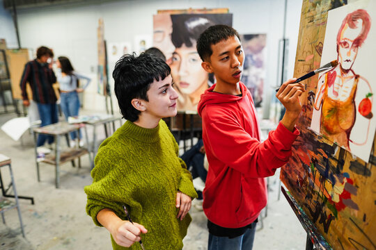 Multiracial students painting inside art room class at school - Back to school and creative education concept - Focus on girl face - UGC content