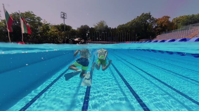 Split View Two Boys Swimming Underwater in Outdoor Pool